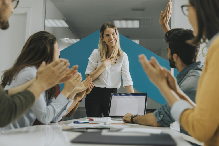Pretty female team leader talking with mixed race group of peopl
